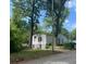 View of the side and back of a one-story house surrounded by mature trees at 1762 Hadlock Street Southwest, Atlanta, GA 30311