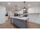 Modern kitchen with an island, white cabinets, pendant lights, and stainless steel appliances at 4367 Cedar Wood Sw Dr, Lilburn, GA 30047