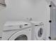 Bright laundry room featuring a side-by-side washer and dryer setup with a door on the side at 701 Smith St, Atlanta, GA 30310