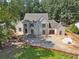 Elegant home featuring light brick, a covered portico, and a meticulously landscaped area, exuding timeless charm at 141 N. Trace, Alpharetta, GA 30009