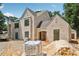 Exterior view of a home with light brick and gabled rooflines, set on a spacious lot at 141 N. Trace, Alpharetta, GA 30009