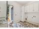 Bright laundry room featuring stylish herring bone brick flooring, cabinets, and exterior door at 141 N. Trace, Alpharetta, GA 30009