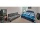 Open bedroom featuring a bed with blue patterned bedding and a gray futon at 2210 Benidorm Ct, South Fulton, GA 30349