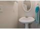 Powder room with a pedestal sink, mirror, and a hand towel, located near an exit door at 2210 Benidorm Ct, South Fulton, GA 30349