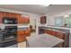 An open concept kitchen features wooden cabinetry, a center island, and a view into the breakfast nook at 2210 Benidorm Ct, South Fulton, GA 30349