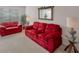 Comfortable living room featuring matching bright red sofa and loveseat with glass end tables at 2210 Benidorm Ct, South Fulton, GA 30349
