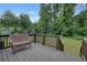Inviting back deck with a wicker bench overlooking the spacious backyard and lush greenery at 276 Indian Creek Dr, Powder Springs, GA 30127
