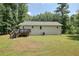 Rear exterior of the home with backyard featuring green grass and mature trees at 276 Indian Creek Dr, Powder Springs, GA 30127