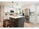 Charming kitchen with white cabinets, stainless appliances, center island with barstool seating, and lovely backsplash at 276 Indian Creek Dr, Powder Springs, GA 30127