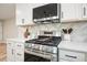 New stainless steel gas range with updated white counters, cabinets, and attractive backsplash at 276 Indian Creek Dr, Powder Springs, GA 30127