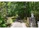 Gated driveway entrance with stone pillars surrounded by dense trees at 7448 Berea Road, Winston, GA 30187