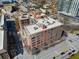 Aerial shot showcasing a brick building with a neighborhood, city streets, and surrounding buildings at 115 W Peachtree Nw Pl # 602, Atlanta, GA 30313