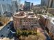 This is an aerial view of the brick building in the city with surrounding streets and greenery at 115 W Peachtree Nw Pl # 602, Atlanta, GA 30313