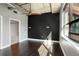 Modern bedroom with a dark accent wall, wood floors, and a view to the bathroom at 115 W Peachtree Nw Pl # 602, Atlanta, GA 30313