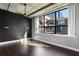 Sleek bedroom with exposed concrete ceiling, dark accent wall, and a large window at 115 W Peachtree Nw Pl # 602, Atlanta, GA 30313
