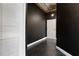 View down a hallway with dark walls and black stone-style tile and a white closet at 115 W Peachtree Nw Pl # 602, Atlanta, GA 30313