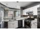 Kitchen featuring white cabinets, stainless steel appliances, and stone countertops with dark floors at 115 W Peachtree Nw Pl # 602, Atlanta, GA 30313