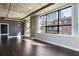 Bright living room featuring hardwood floors, concrete ceilings, and large windows with city views at 115 W Peachtree Nw Pl # 602, Atlanta, GA 30313