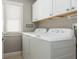 Bright laundry room featuring a washer and dryer with overhead cabinets and a window for natural light at 2075 Old Georgian Nw Ter, Atlanta, GA 30318