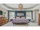 The main bedroom features a navy accent wall, tray ceiling, and chandelier at 2075 Old Georgian Nw Ter, Atlanta, GA 30318