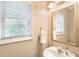 Powder room featuring elegant mirror, pedestal sink, and window with blinds at 2584 Oglethorpe Ne Cir, Brookhaven, GA 30319