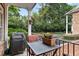 Outdoor patio with seating and grill, surrounded by mature trees and lush landscaping at 2584 Oglethorpe Ne Cir, Brookhaven, GA 30319