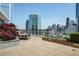 Enjoy city views on this spacious patio with an outdoor dining area and lovely landscaping at 3325 Piedmont Ne Rd # 2501, Atlanta, GA 30305