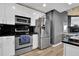 Modern kitchen with stainless steel appliances, sleek white cabinetry, and a black tile backsplash at 361 17Th St # 1121, Atlanta, GA 30363