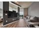 Open concept living room featuring hardwood floors, concrete ceilings, a large TV, and a comfortable grey couch at 361 17Th St # 1121, Atlanta, GA 30363