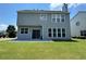 Back exterior view showcasing sliding glass door with a large grass area at 8965 Friarbridge Dr, Suwanee, GA 30024
