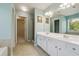 Spacious bathroom with dual sinks, a large mirror, a walk-in closet, and a shower at 8965 Friarbridge Dr, Suwanee, GA 30024