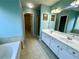 En-suite bathroom with double sinks, a soaking tub, separate shower, and walk-in closet at 8965 Friarbridge Dr, Suwanee, GA 30024