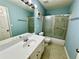 Cozy bathroom featuring shower over bath with patterned glass doors, and a white vanity at 8965 Friarbridge Dr, Suwanee, GA 30024