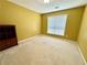 Bedroom showcasing neutral carpet, a large window, and a built-in shelf unit at 8965 Friarbridge Dr, Suwanee, GA 30024