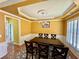 Formal dining room features decorative molding, a tray ceiling, and a large table with seating for four at 8965 Friarbridge Dr, Suwanee, GA 30024