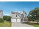 Attractive two-story home with a stone facade, a two-car garage, and mature trees at 8965 Friarbridge Dr, Suwanee, GA 30024
