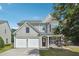 Charming two-story home with stone details, a two-car garage, and lush landscaping at 8965 Friarbridge Dr, Suwanee, GA 30024