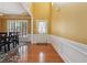 Elegant foyer with hardwood floors, wainscoting, and a view of the dining area at 8965 Friarbridge Dr, Suwanee, GA 30024
