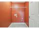 Laundry room with overhead wire shelving and orange walls at 8965 Friarbridge Dr, Suwanee, GA 30024