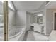 Bright bathroom featuring a large tub, vanity with white cabinets, and carpet flooring at 1024 Cromwell Pt, Snellville, GA 30078