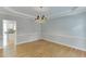 Elegant dining room with hardwood floors, a decorative chandelier, and an archway into the kitchen at 1024 Cromwell Pt, Snellville, GA 30078