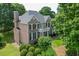 Elegant brick home with a balcony, complemented by mature trees and a meticulously maintained garden at 1024 Cromwell Pt, Snellville, GA 30078