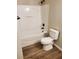 Clean bathroom with a shower and tub combo with a white toilet and wood-style flooring at 2748 Farmstead Ct, Grayson, GA 30017