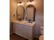 Bright bathroom showcasing a double vanity with marble countertop and arched mirrors with modern lighting at 2748 Farmstead Ct, Grayson, GA 30017