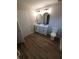 Bathroom featuring a double sink vanity, arched mirrors, modern lighting and wood look floors at 2748 Farmstead Ct, Grayson, GA 30017
