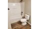 Clean bathroom with a shower and tub combo with a white toilet and wood-style flooring at 2748 Farmstead Ct, Grayson, GA 30017