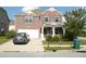 Charming two-story brick home boasts a covered front porch, two-car garage, and manicured landscaping at 2748 Farmstead Ct, Grayson, GA 30017