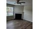 Bright living room featuring a fireplace, modern flooring, and a large window with natural light at 2748 Farmstead Ct, Grayson, GA 30017