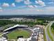 Wide aerial view of stadium, highway, mixed use buildings, and community in the background at 2625 Poppy Ct, Buford, GA 30519