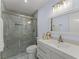Bathroom featuring a glass-enclosed shower, modern vanity, and a decorative mirror at 2886 Webb Bridge Rd, Alpharetta, GA 30009